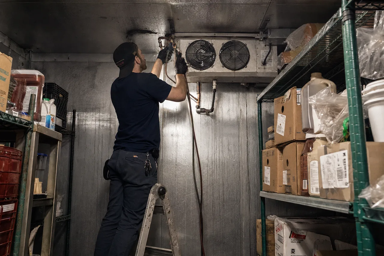 Technician servicing a walk-in cooler in a Yonkers kitchen